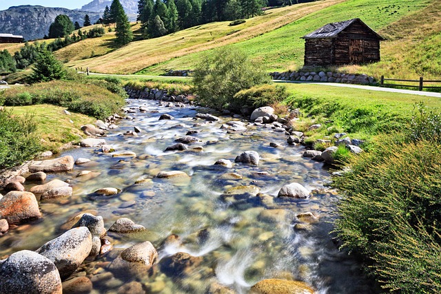 Paesaggio valtellinese con borgo in pietra, piazzetta e fontana al tramonto